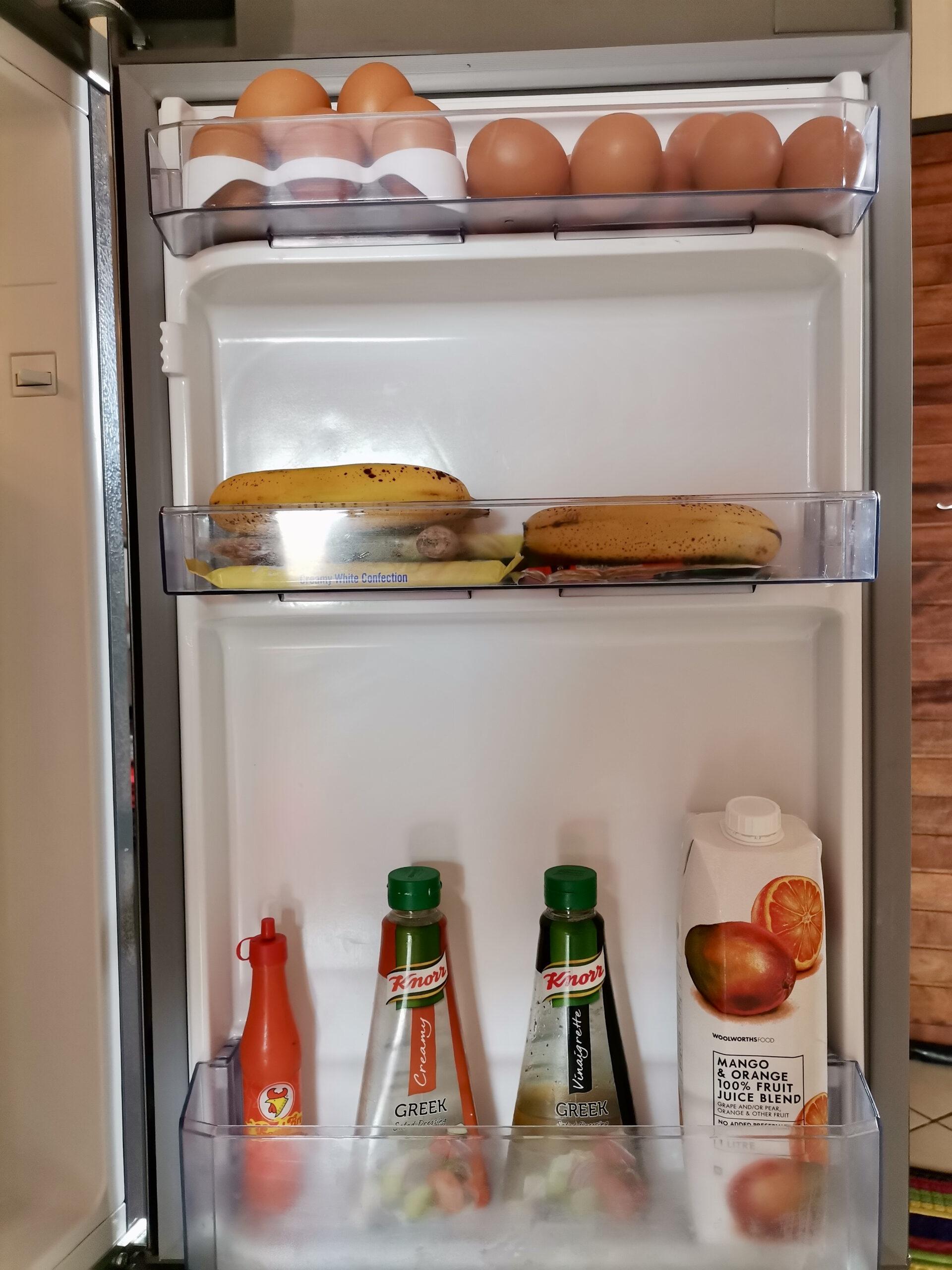 Fruit, eggs, juice and sauces in fridge door