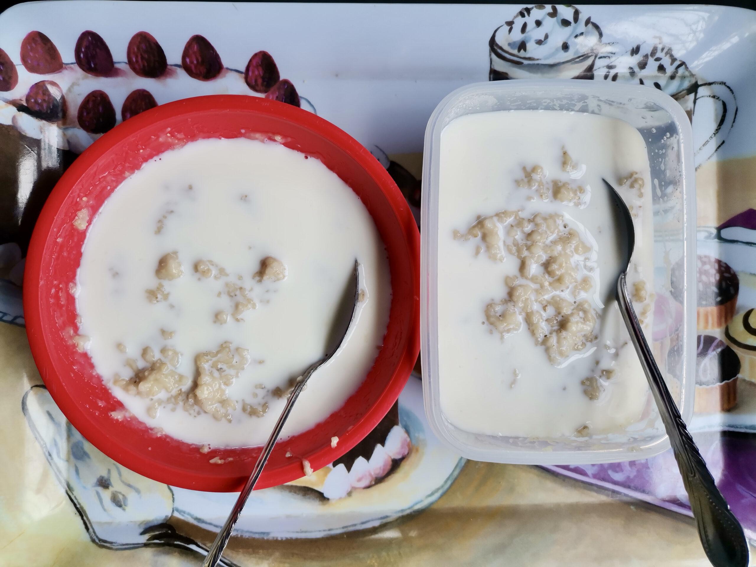 Cooked oat porridge with milk served in plastic containers