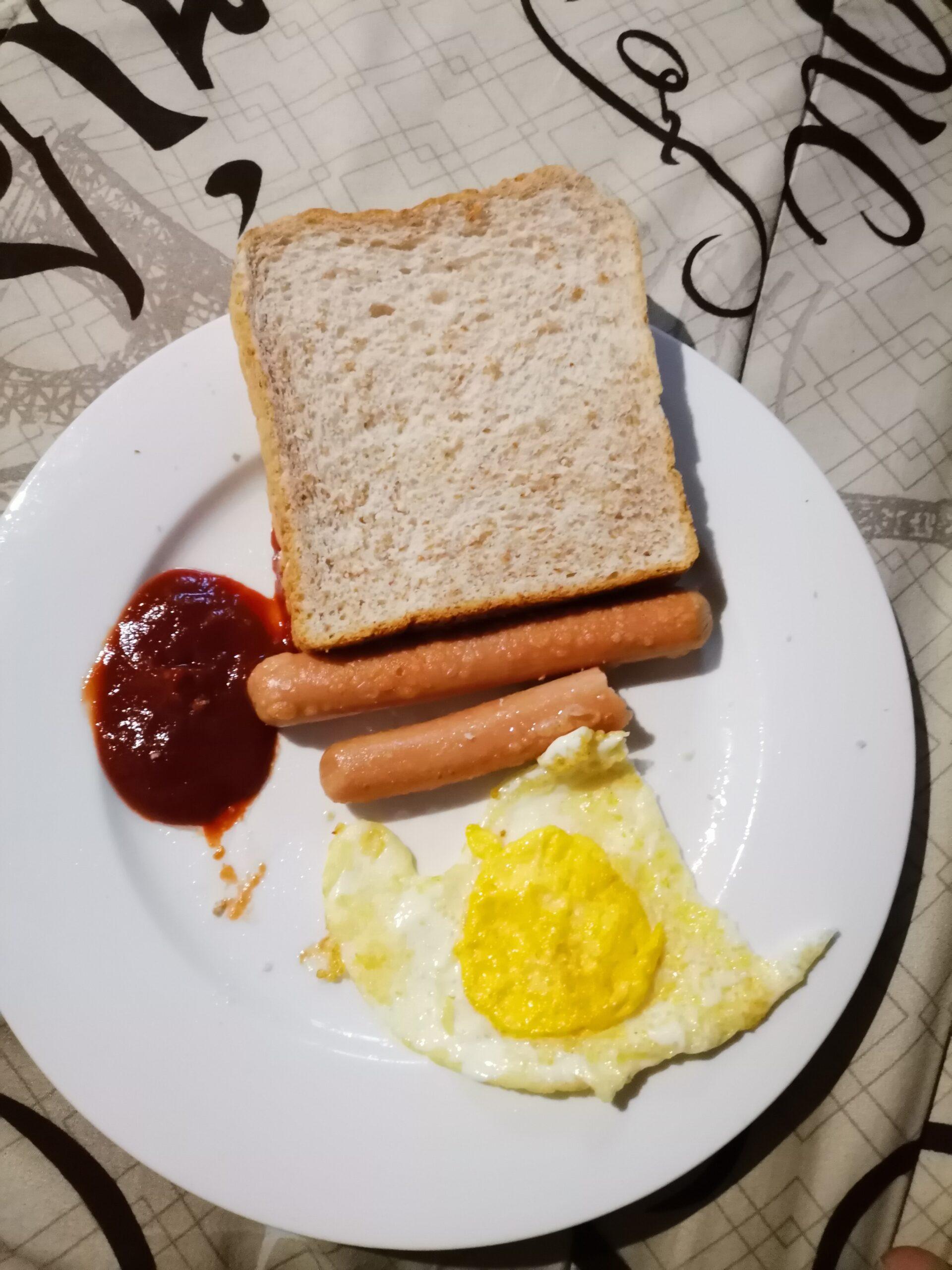 Fried egg, Vienna sausages, brown bread and tomato sauce