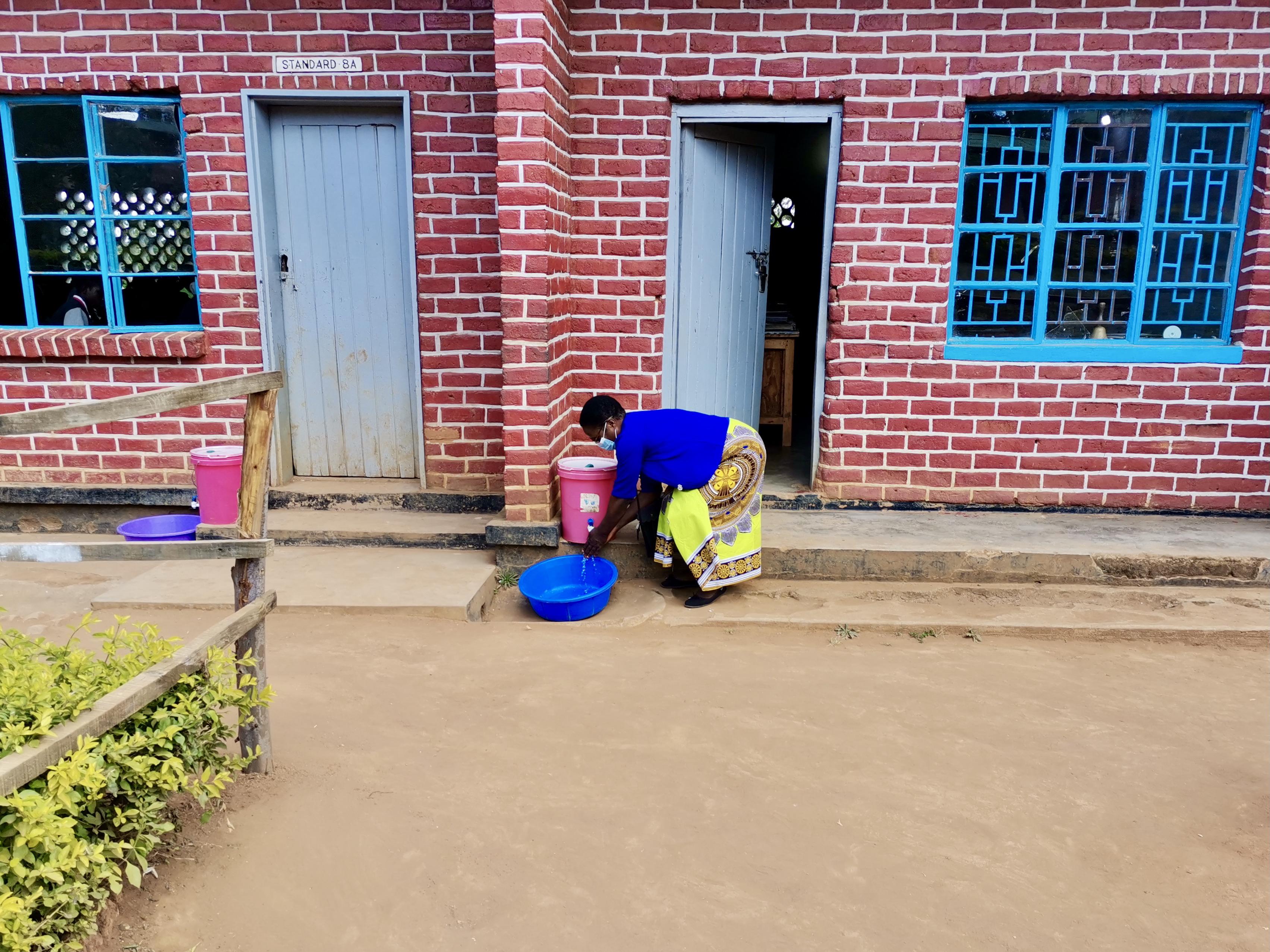Woman washing her hands outside a classroom door
